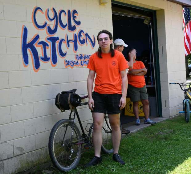 Cycle kitchen director Kuba Jennes poses in front of artwork he created for the organization as he stands near his bike on SaturdayJuly 25, 2026. (GERI GIBBONS/STAFF PHOTO)