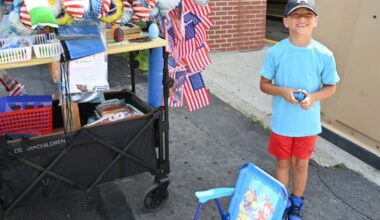 Levy Barr, 6, helps his father promote patriotic memorabilia during...