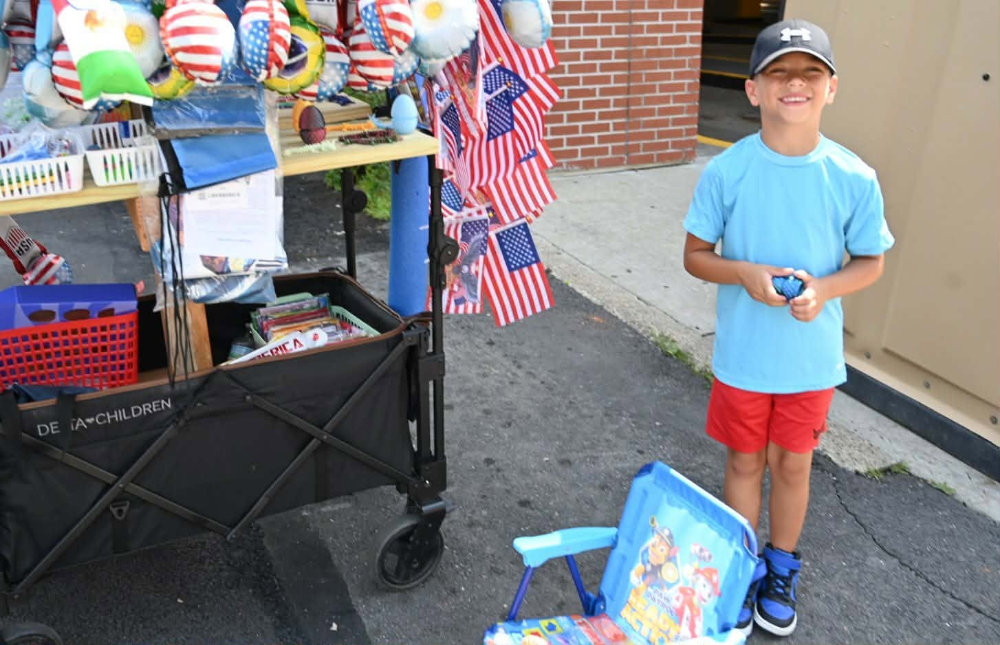 Levy Barr, 6, helps his father promote patriotic memorabilia during...