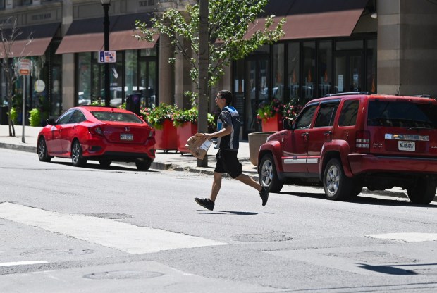 A man crosses N. Washington Ave. in downtown Scranton Monday, July 13, 2026. (SEAN MCKEAG / STAFF PHOTOGRAPHER)