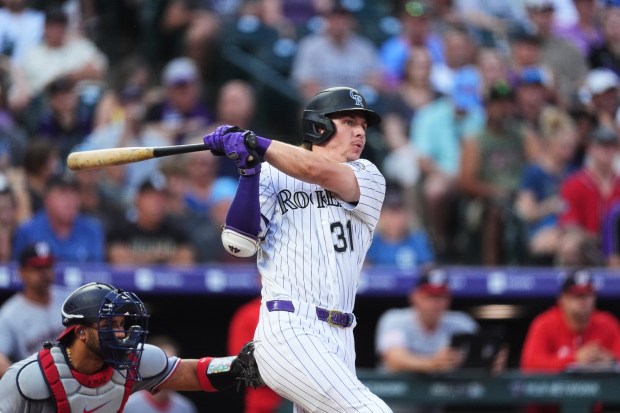 Colorado Rockies' Jake McCarthy follows the flight of his RBI double off Washington Nationals starting pitcher Carson Palmquist in the second inning of a baseball game, Tuesday, July 21, 2026, in Denver. (AP Photo/David Zalubowski)