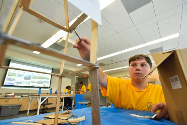 Noah Keiper, of Scranton, works on painting a hydro-electric dam during an interactive workshop on sustainability and solar cells at the University of Scranton's Leahy Hall in Scranton Wednesday, July 15, 2026. (SEAN MCKEAG / STAFF PHOTOGRAPHER)