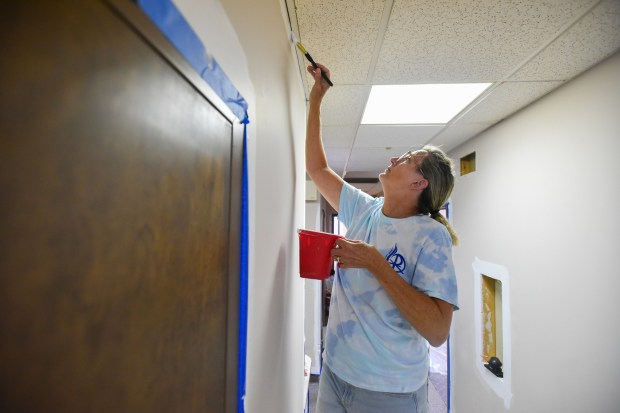 Alison Corcoran, of Allendale, NJ, paints with other members of the New Jersey-based Church of the Presentation, as part of the Catholic Heart Work Camp at the Friends of the Poor & Catherine McAuley Center furniture bank and home good warehouse on Fellows Street in Scranton Wednesday, July 15, 2026. (SEAN MCKEAG / STAFF PHOTOGRAPHER)