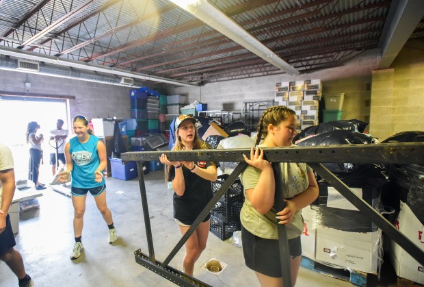 Bailey Gornell, of Waldwick, NJ, and Julia Guarascio, of Nanuet, NY, carry a bed frame as they rearrange the Friends of the Poor & Catherine McAuley Center furniture bank and home good warehouse on Fellows Street in Scranton Wednesday, July 15, 2026. (SEAN MCKEAG / STAFF PHOTOGRAPHER)