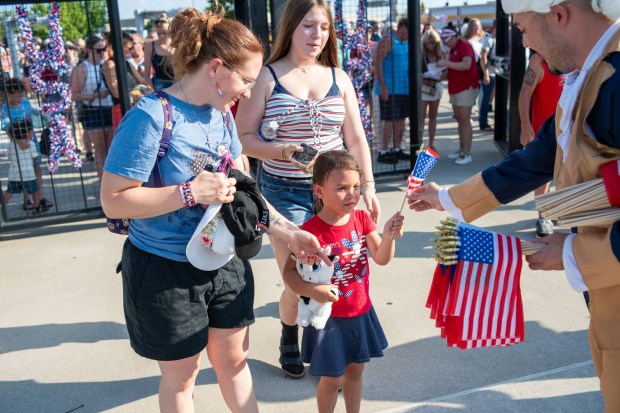Attendees receive American flags at the entrance to Coca-Cola Park Friday, July 3, 2026, during the Liberty Ignited celebration marking America's 250th birthday in Allentown. (Jonathan Broady/Special to The Morning Call)