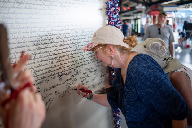 Attendees sign their names on a replica of the Declaration of Independence Friday, July 3, 2026, during the Liberty Ignited celebration marking America's 250th birthday at Coca-Cola Park in Allentown. (Jonathan Broady/Special to The Morning Call)