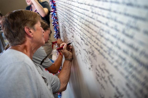 Attendees sign their names on a replica of the Declaration of Independence Friday, July 3, 2026, during the Liberty Ignited celebration marking America's 250th birthday at Coca-Cola Park in Allentown. (Jonathan Broady/Special to The Morning Call)
