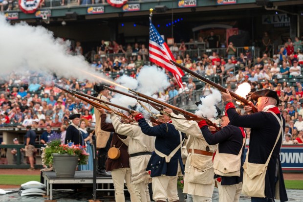 Members of the Bachmann Players perform as a town crier, Benjamin Franklin reads the Declaration of Independence, and Colonial soldiers present a musket salute Friday, July 3, 2026, during the Liberty Ignited celebration marking America's 250th birthday at Coca-Cola Park in Allentown. (Jonathan Broady/Special to The Morning Call)