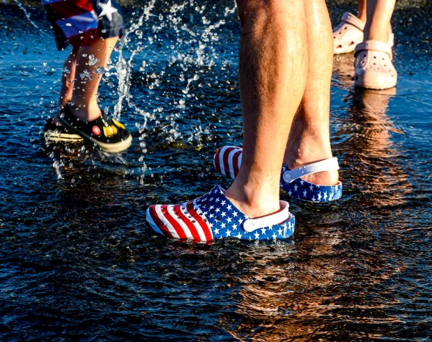 Children and families cool down under the spray Thursday, July 2, 2026, in Coopersburg during a free community cool off event featuring Coopersburg Fire Company's ladder truck spraying water. (April Gamiz/The Morning Call)