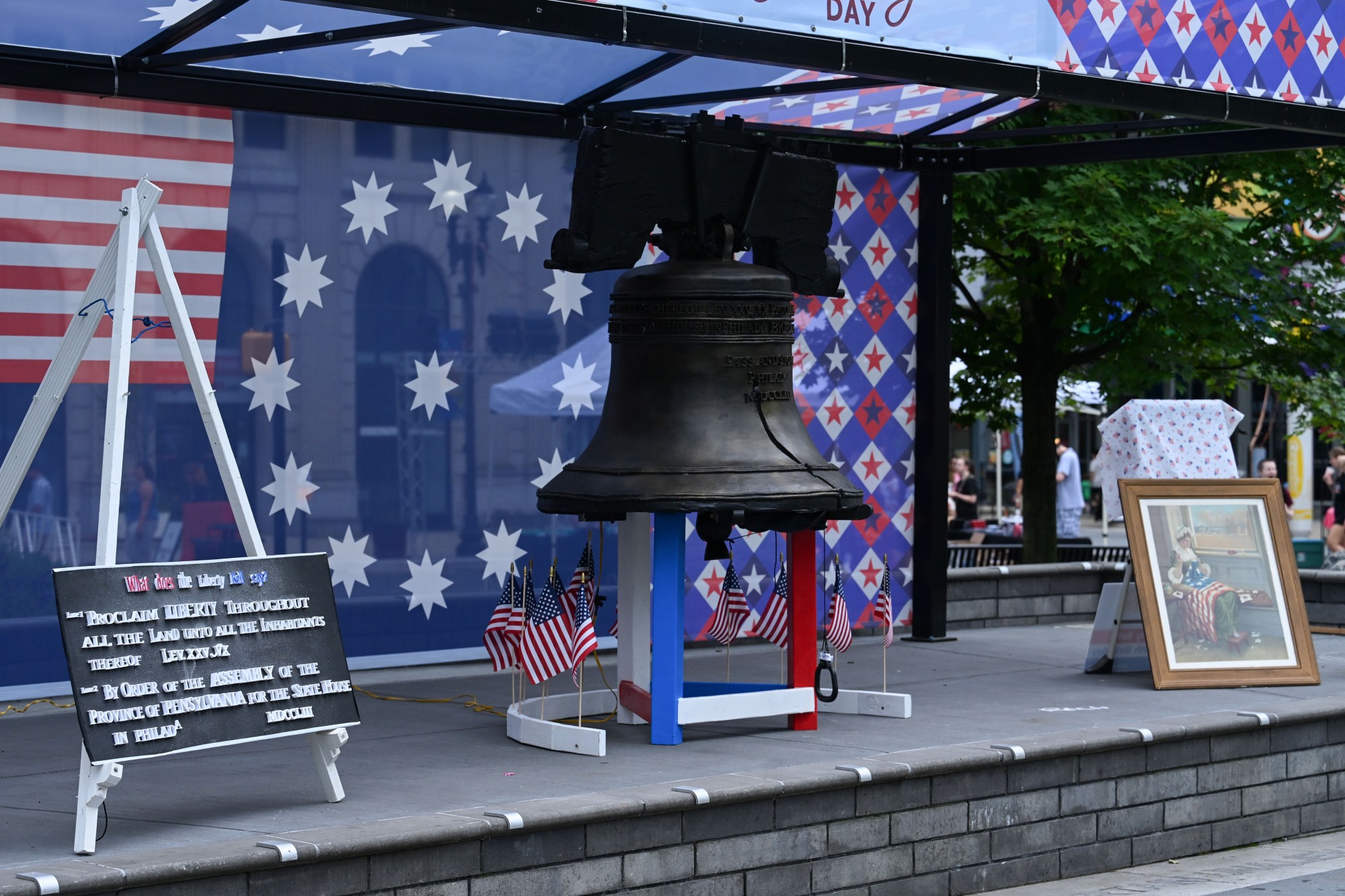 A paper mache replica of the Liberty Bell sits on display next to a painting of Betsy Ross making the first American Flag on Saturday, July 11, 2026, during the Heritage Day festival in Easton. The festival showcases local and regional history and the heritage of many groups with reenactment events, recreational activities and musical performances. (Jon Chiu/The Morning Call)