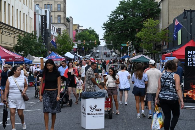 People walk among stands Saturday, July 11, 2026, during the Heritage Day festival in Easton. The festival showcases local and regional history and the heritage of many groups with reenactment events, recreational activities and musical performances. (Jon Chiu/The Morning Call)