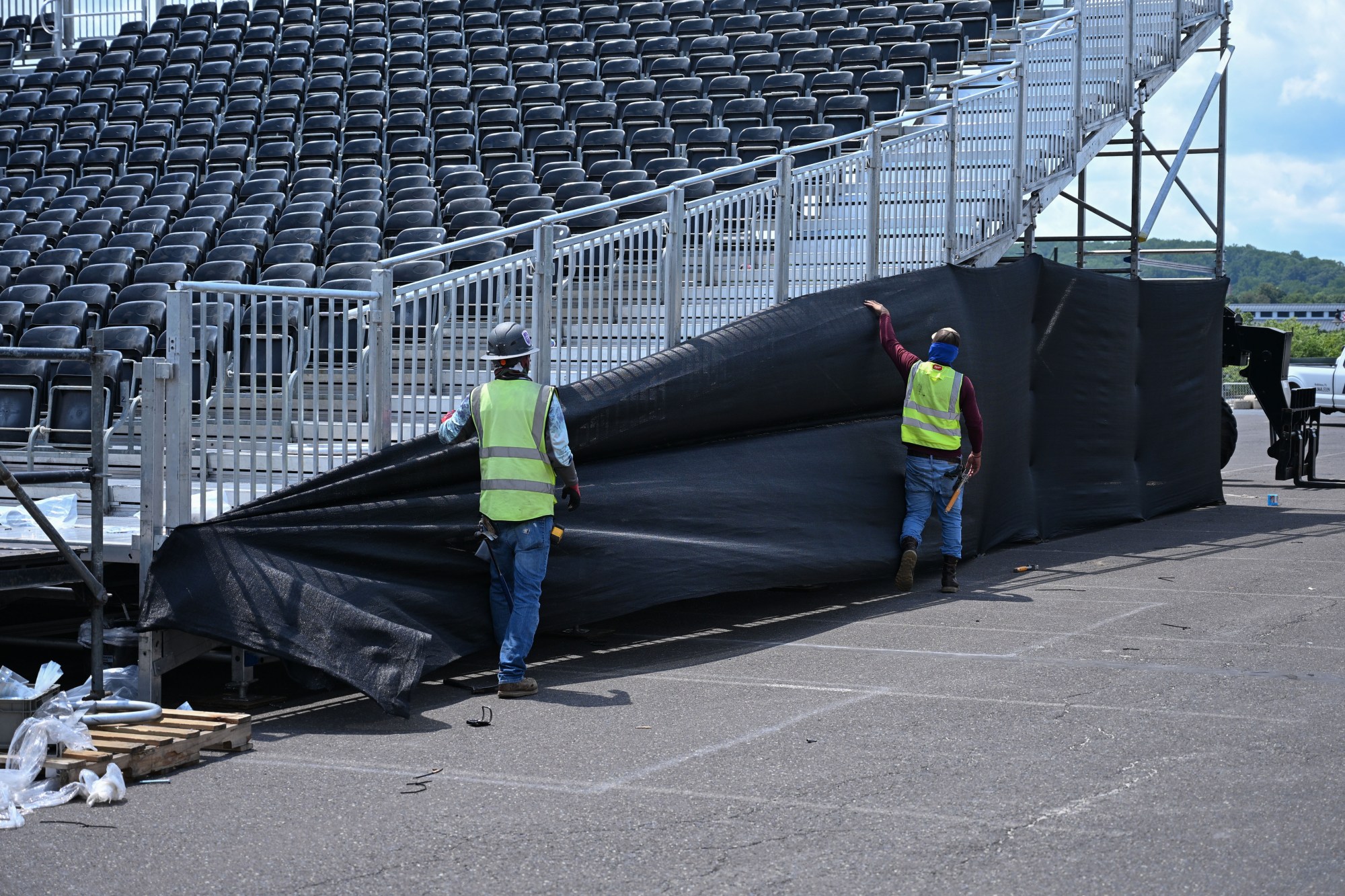 Workers hang a tarp on the side of a set of bleachers in preparation for Musikfest on Wednesday, July 22, 2026, in Bethlehem. The 10-day, free music festival in both North and South Side Bethlehem runs July 31-Aug. 9. (Jon Chiu/The Morning Call)