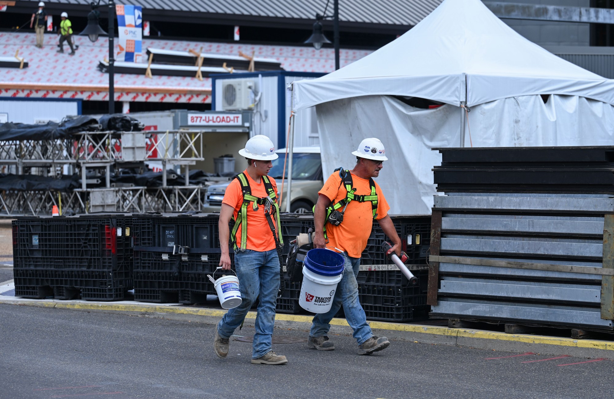 A pair of workers from another construction site walk through the PNC Plaza during preparations for Musikfest on Wednesday, July 22, 2026, in Bethlehem. The 10-day, free music festival in both North and South Side Bethlehem runs July 31-Aug. 9. (Jon Chiu/The Morning Call)