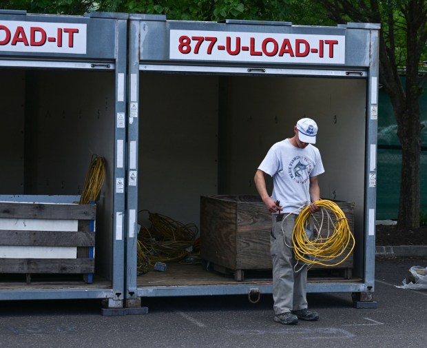 Josh Klusaritz of Northampton, who works for Albarell Electric, collects power cables from a trailer during preparations for Musikfest on Wednesday, July 22, 2026, in Bethlehem. The 10-day, free music festival in both North and South Side Bethlehem runs July 31-Aug. 9. (Jon Chiu/The Morning Call)