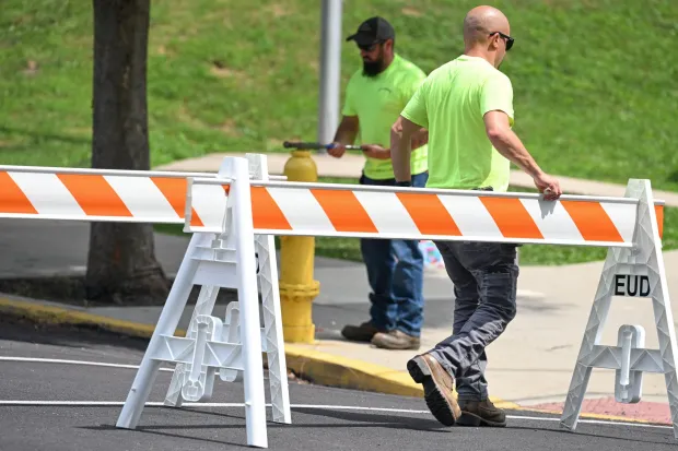 Utility workers close off a section of Reeder Street by March Elementary School to open a fire hydrant Wednesday, July 15, 2026, in Easton. Eight of the city's hydrants will be open again from noon to 6 p.m. Thursday to combat soaring temperatures. (Jon Chiu/The Morning Call)