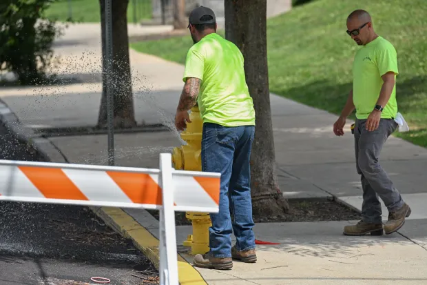 Utility workers open a fire hydrant at the intersection of Parsons and Reeder streets near March Elementary School on Wednesday, July 15, 2026, in Easton. Eight of the city's hydrants will be open again from noon to 6 p.m. Thursday to combat soaring temperatures. (Jon Chiu/The Morning Call)