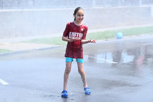 Vanessa Bahrt, 7, of Easton plays in water flowing from an open fire hydrant Wednesday, July 15, 2026, between Cottingham Stadium and Paxinosa Elementary School in Easton. Eight of the city's hydrants will be open again from noon to 6 p.m. Thursday to combat soaring temperatures. (Jon Chiu/The Morning Call)