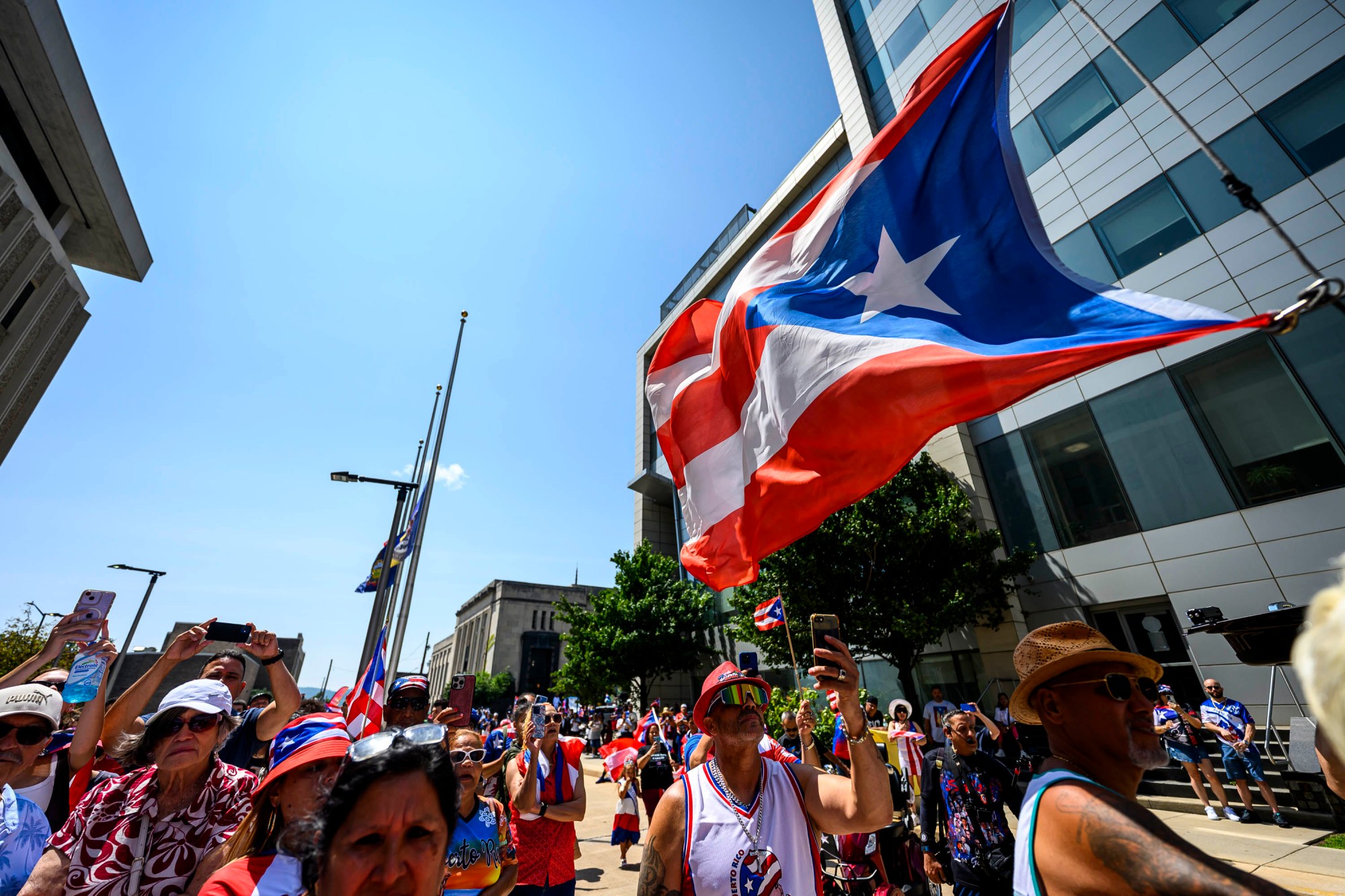 People celebrate raising the raising the Puerto Rican flag before the annual Lehigh Valley Puerto Rican Day Parade on Sunday, July 19, 2026, in Allentown. The day's festivities, sponsored by Puertorrican Cultural Preservation, also included raising the Puerto Rican flag and a festival. (April Gamiz/The Morning Call)
