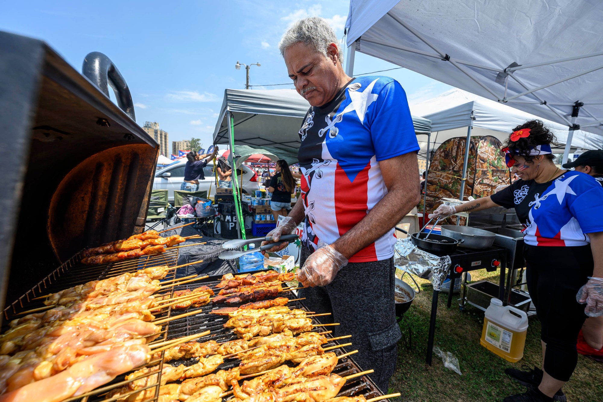 Alberto DeLeon grills fresh pollo pinchos (chicken on a stick) during the annual Lehigh Valley Puerto Rican Day Festival on Sunday, July 19, 2026, at the Allentown Fairgrounds. The day's festivities, sponsored by Puertorrican Cultural Preservation, also included raising the Puerto Rican flag and a parade. (April Gamiz/The Morning Call)
