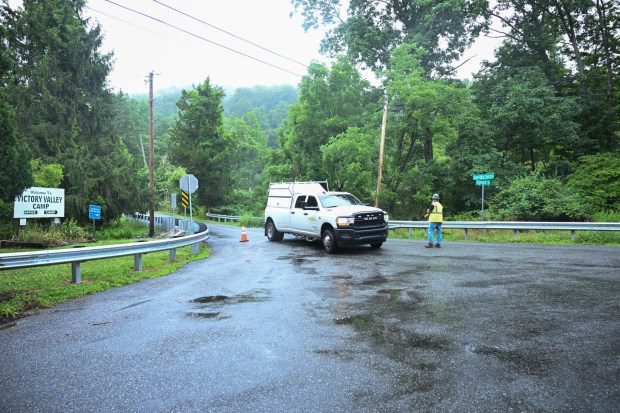 Workers clear storm damage Tuesday, July 7, 2026, near Victory Valley Camp in Upper Milford Township. Storms that hit the Lehigh Valley over the weekend caused road closures and electricity outages throughout the region. Utilities said it could take until Thursday to fully restore power. (Jon Chiu/The Morning Call)