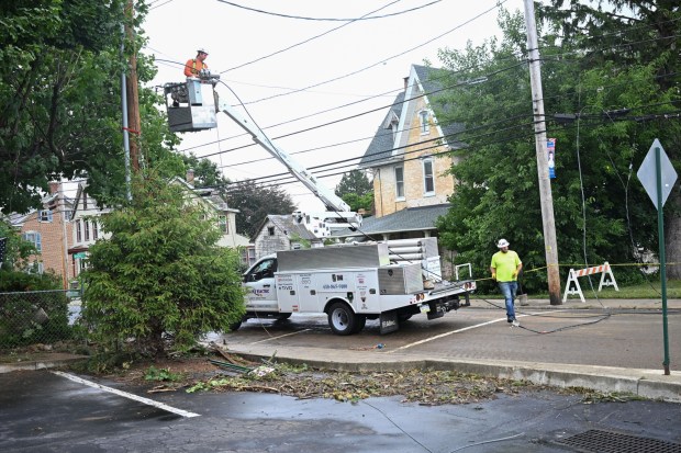 Workers repair damaged power lines Tuesday, July 7, 2026, in Alburtis. Storms that hit the Lehigh Valley over the weekend caused road closures and electricity outages throughout the region. Utilities said it could take until Thursday to fully restore power. (Jon Chiu/The Morning Call)