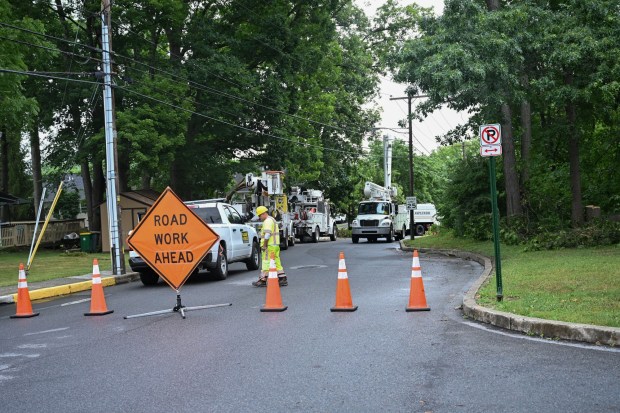 Utility vehicles park on the side of the road to help clear storm damage on Tuesday, July 7, 2026, in Alburtis. Utilities said it could take until Thursday to fully restore power. (Jon Chiu/The Morning Call)