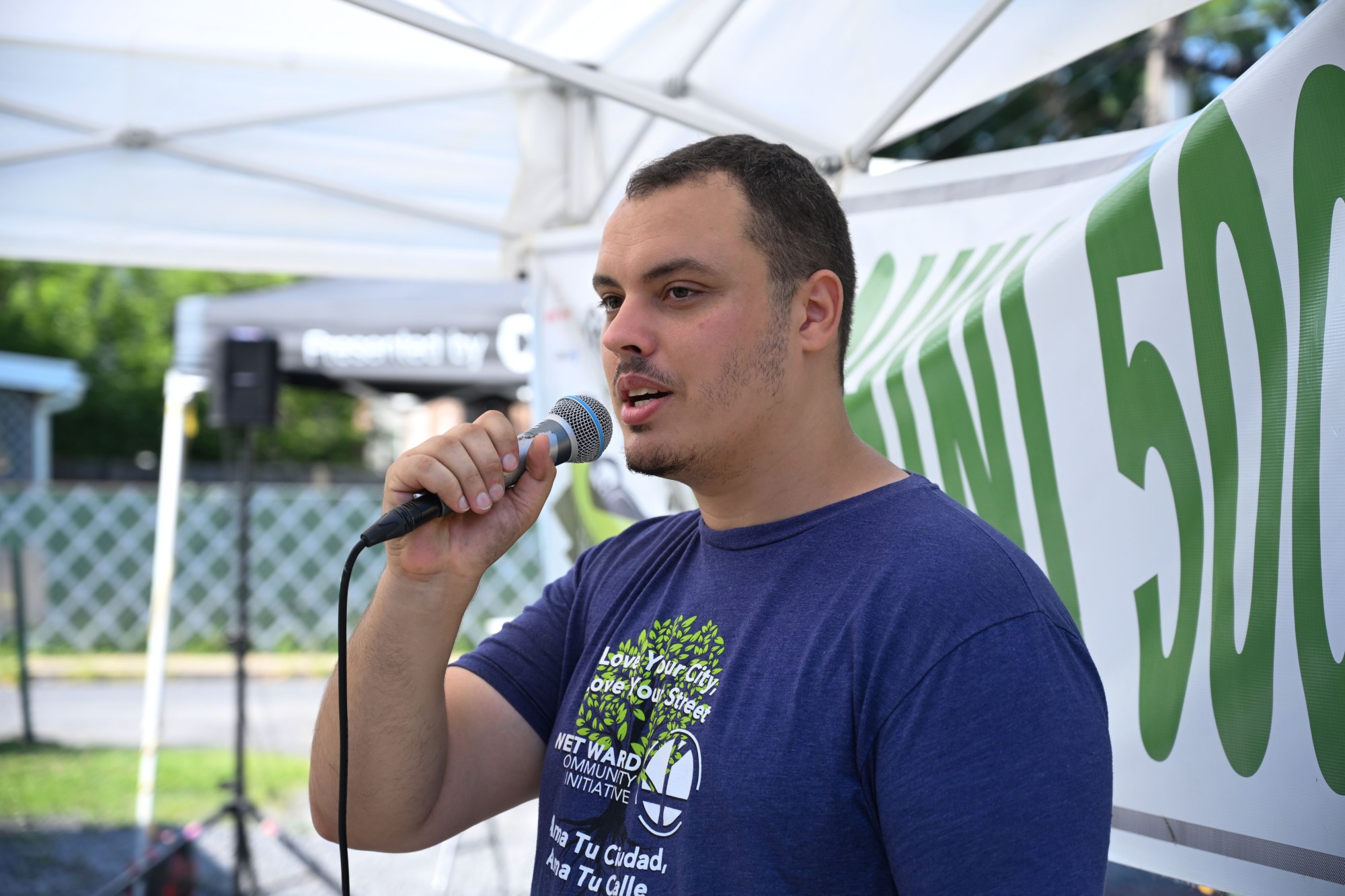 West Ward Community Initiative manager Jacob Behler makes announcements during the 20th Annual Zucchini 500 on Thursday, July 23, 2026 at the 10th & Pine street community garden in Easton. According to Behler, events like the 'Zuke 500' are meant to help foster new community connections and help people have affordable and local access to healthy produce. (Jon Chiu/The Morning Call)