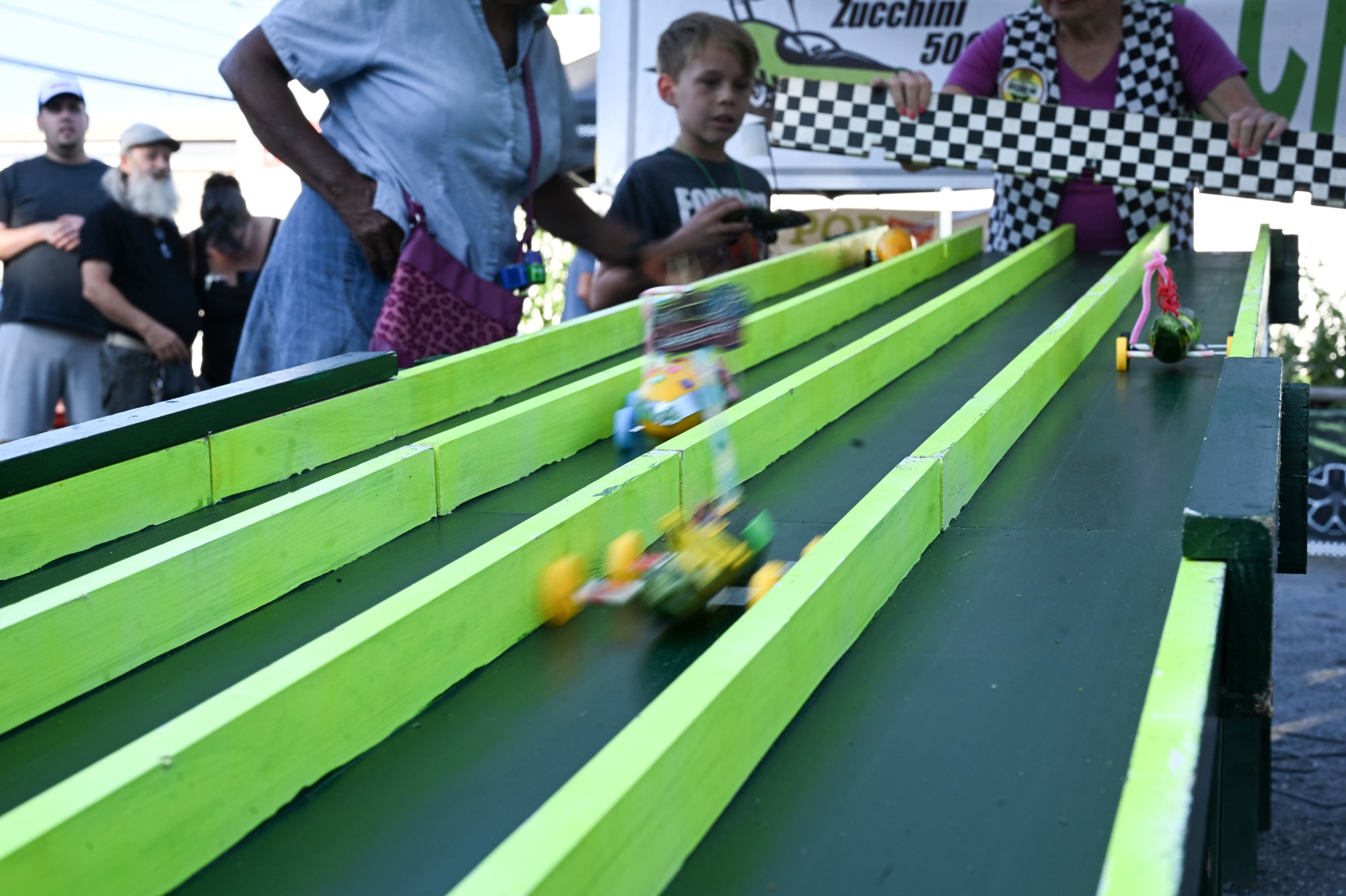 Zucchini cars race down the track during the 20th Annual Zucchini 500 on Thursday, July 23, 2026 at the 10th & Pine street community garden in Easton. According to West Ward Community Initiative manager Jacob Behler, events like the 'Zuke 500' are meant to help foster new community connections and help people have affordable and local access to healthy produce. (Jon Chiu/The Morning Call)