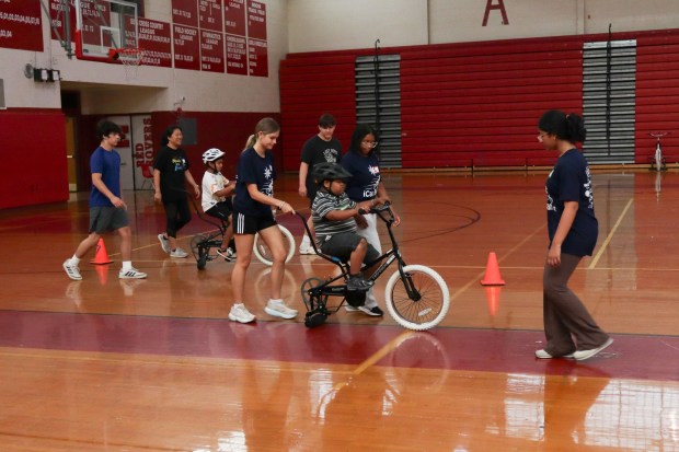 Children with disabilities ride training bicycles, some with help of volunteers, during an iCanBike session Wednesday, July 29, 2026, at Easton Area High School in Palmer Township. iCanBike will remain at the high school to teach individuals with various disabilities how to ride both training and conventional bicycles until Friday. (Jon Chiu/The Morning Call)