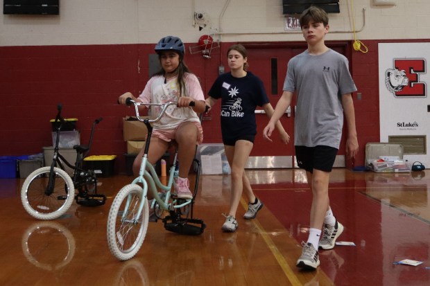 Connor Koshy of Warrington, 13, rides a training bicycle with help from iCanBike volunteers Wednesday, July 29, 2026, at Easton Area High School in Palmer Township. iCanBike will remain at the high school to teach individuals with various disabilities how to ride both training and conventional bicycles until Friday. (Jon Chiu/The Morning Call)