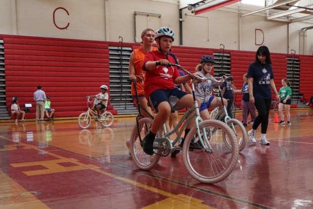 Children with disabilities ride training bicycles, some with help of volunteers, during an iCanBike session Wednesday, July 29, 2026, at Easton Area High School in Palmer Township. iCanBike will remain at the high school to teach individuals with various disabilities how to ride both training and conventional bicycles until Friday. (Jon Chiu/The Morning Call)