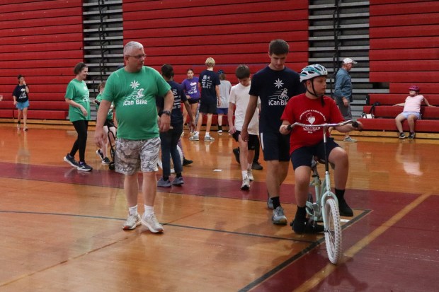 Volunteers from iCanBike watch over children as they ride bicycles Wednesday, July 29, 2026, at Easton Area High School in Palmer Township. iCanBike will remain at the high school to teach individuals with various disabilities how to ride both training and conventional bicycles until Friday. (Jon Chiu/The Morning Call)