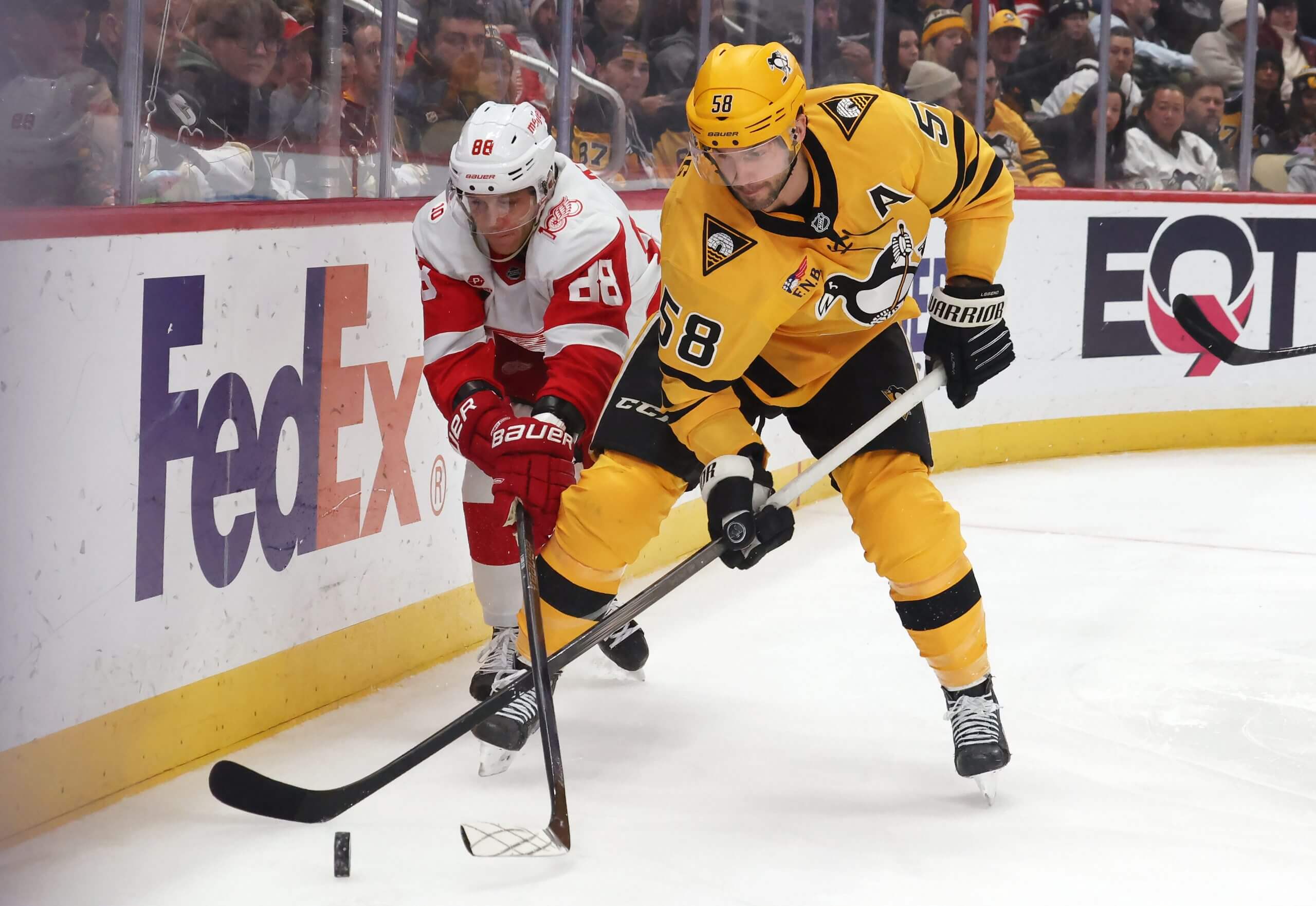 Detroit Red Wings right wing Patrick Kane and Pittsburgh Penguins defenseman Kris Letang chase the puck near the wall at PPG Paints Arena.