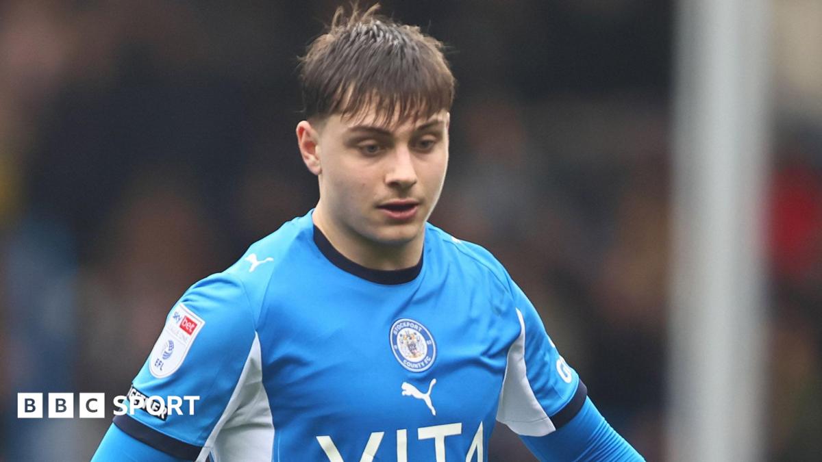 Josh Stokes wearing the blue shirt of Stockport County