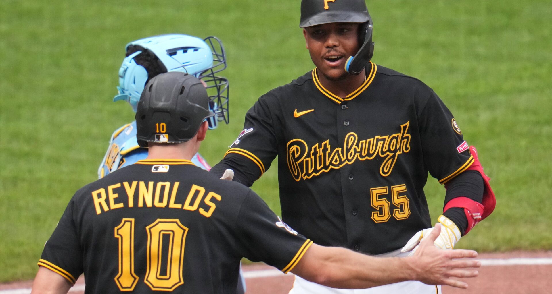 Pittsburgh Pirates' Esmerlyn Valdez (55) celebrates with Bryan Reynolds (10) after hitting a two-run home run off Milwaukee Brewers pitcher Shane Drohan during the fourth inning of the second game of a baseball doubleheader in Pittsburgh, Saturday, July 11, 2026. (AP Photo/Gene J. Puskar)