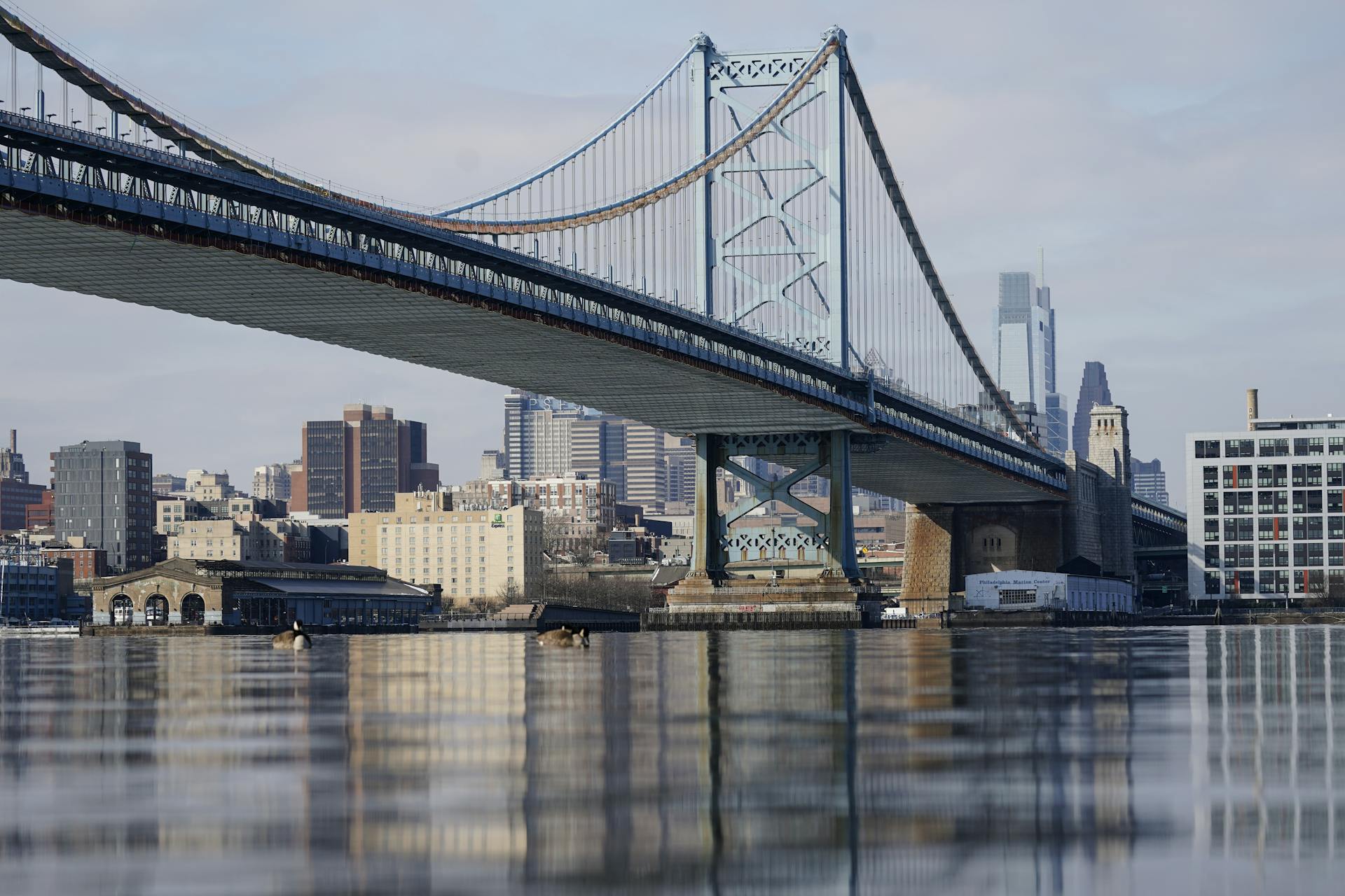View of large body of water with bridge over it and city skyline in background
