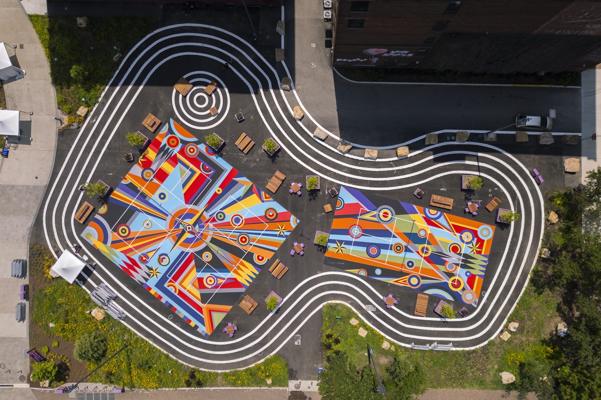 a drone view of three pickleball courts in downtown Pittsburgh painted with bright geometric, abstract murals