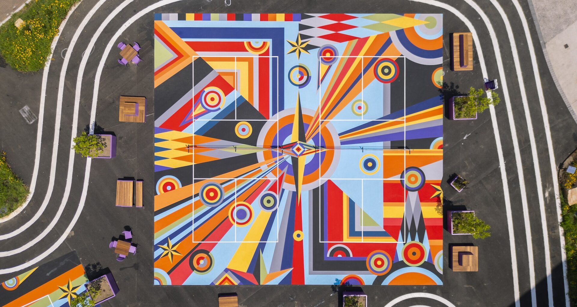a drone view of two of three pickleball courts in downtown Pittsburgh painted with bright geometric, abstract murals