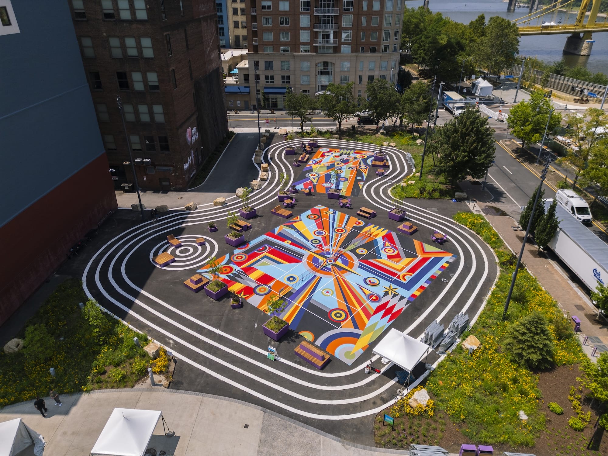 a drone view of three pickleball courts in downtown Pittsburgh painted with bright geometric, abstract murals