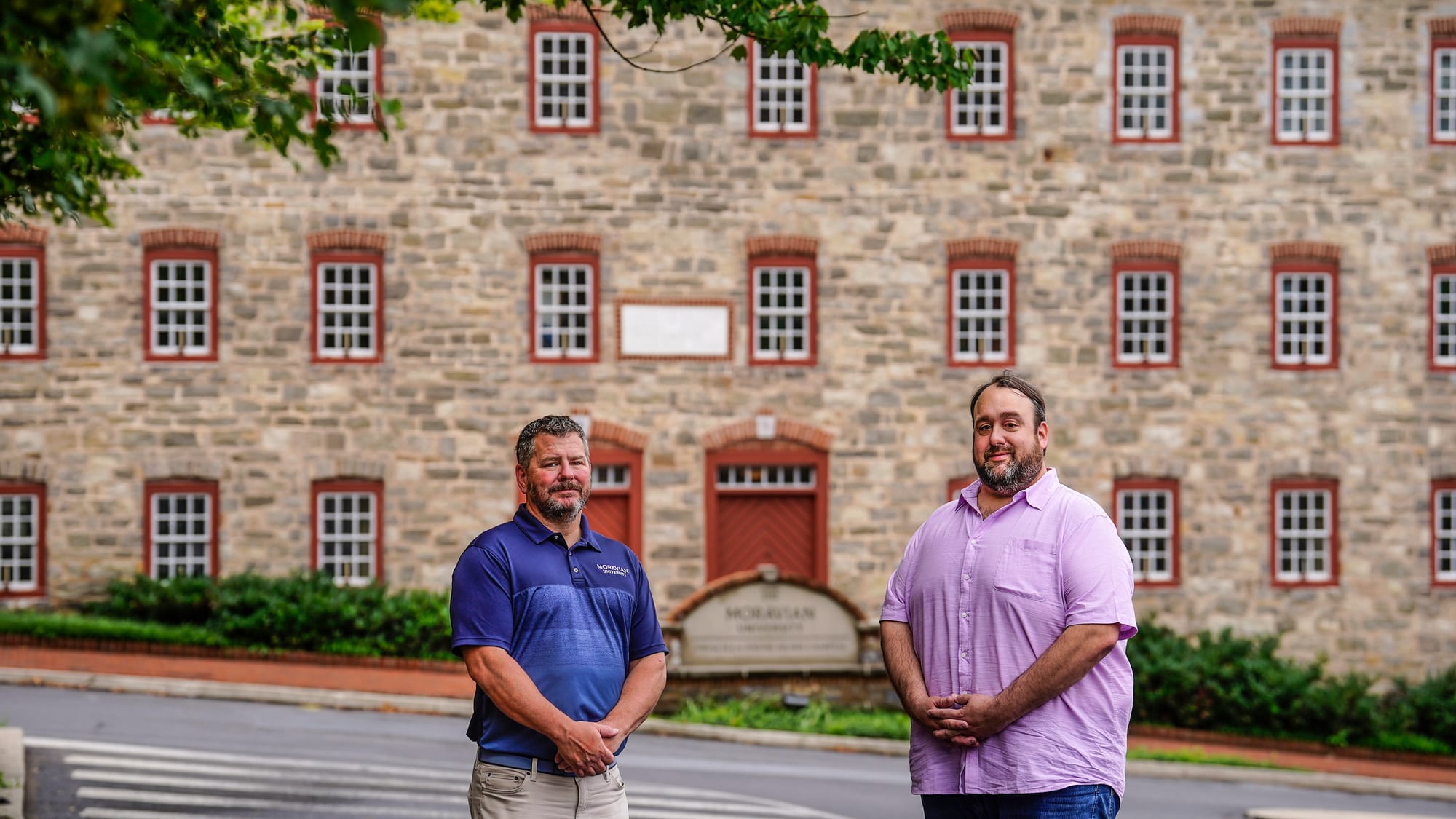 Moravian University representatives Michael Corr, left, and Mike Cook stand in front of the Brethren House which today is par