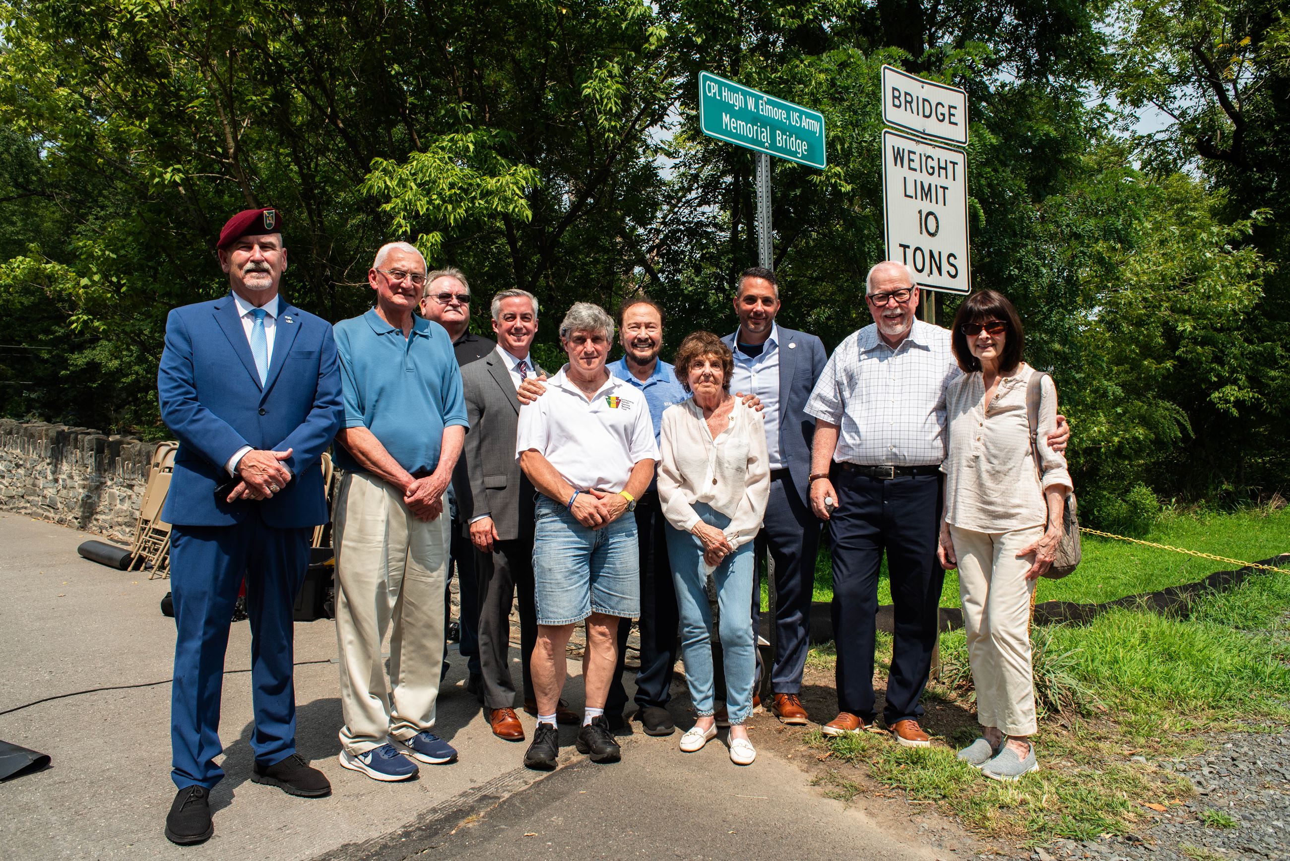 People standing next to a sign