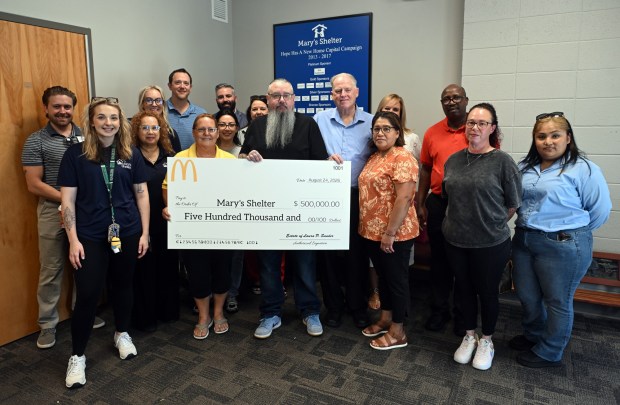 Christine Folk, executive director of Mary's Shelter, and Christopher Sander of Coatesville, son of Linda Sander, a shelter benefactor, hold a $500,00 gift from Linda Sander presented to the shelter on Monday, Aug. 24, 2026. (BILL UHRICH/READING EAGLE)