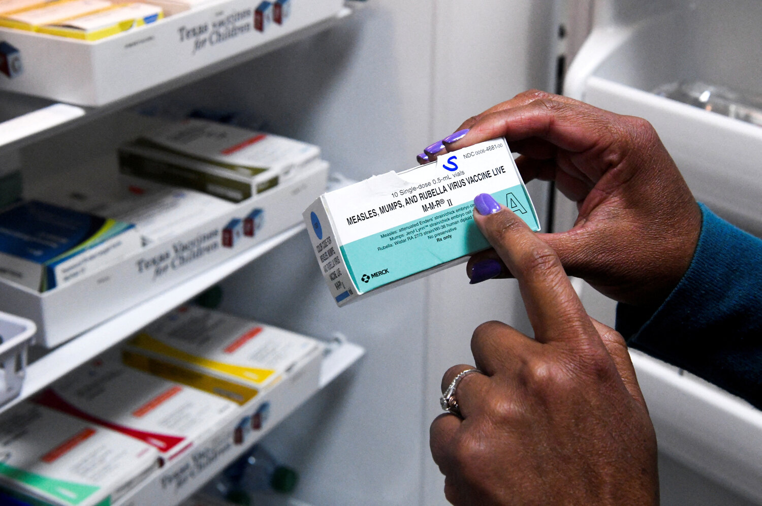 A doctor points to MMR (measles, mumps and rubella) vaccines.