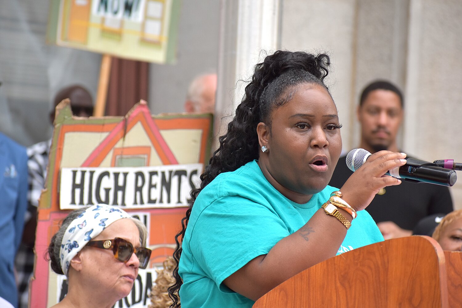 Latoya Burgess, who lives in a property owned by Neighborhood Restorations, speaks at a rally Tuesday, Aug. 11, outside City Hall.