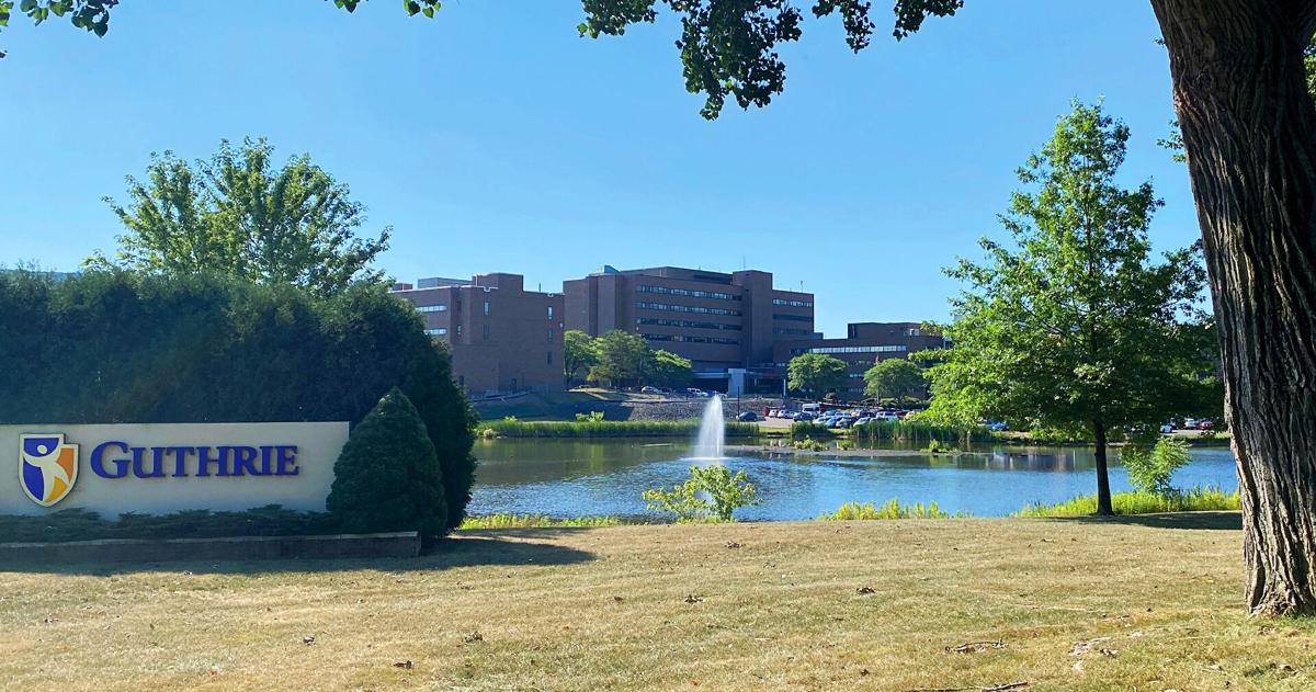 A health system campus framed by trees with a sign that says “Guthrie.” |