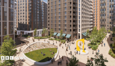 A CGI image of a housing development showing tower blocks centred around a large square with paved and green space, trees, and a yellow archway sculpture. There are people walking through the square.
