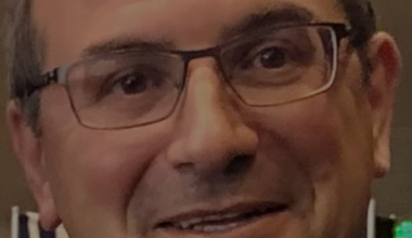person with glasses smiling