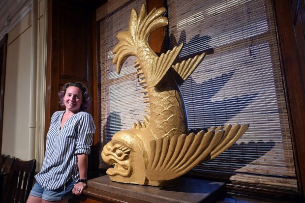 Alexa Freyman, president of the Foundation for the Reading Pagoda, with a third cast of a shachihoko, a mythical Japanese creature that protects the building upon which it sits. The creatures were cast in the early 1970s by artist Bess Bast of Kutztown and placed atop the Pagoda in 1975. (BILL UHRICH/READING EAGLE)