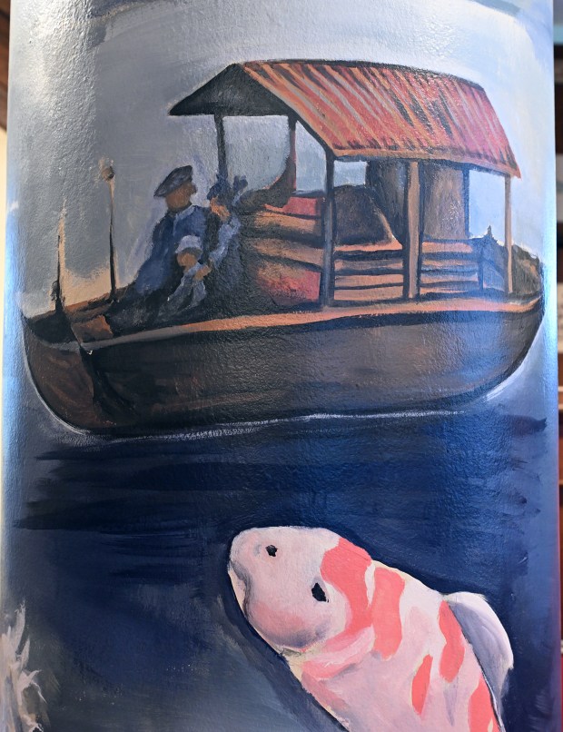 Reading artist Theron Cook worked with his son Leo, 10, to add a family to the Japanese fishing boat in a mural inside the Pagoda lobby. (BILL UHRICH/READING EAGLE)