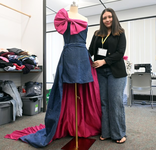Sarai Martinez Najarro, 17, a senior at Reading High, displays a denim dress with train she created during Alvernia University's Total Experience Learning Fashion and Sustainability Camp. (BILL UHRICH/READING EAGLE)